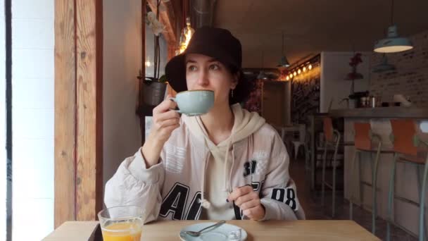 Ένα κορίτσι τρώει πρωινό σε ένα καφέ. — Αρχείο Βίντεο