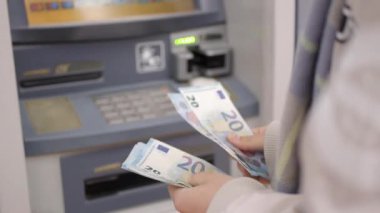 Para kazanmak için ATM kullanan bir kadın..