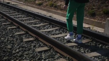 Tren raylarında bir genç.