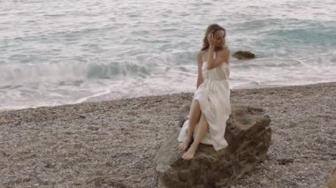 Plajda oturan bir manken.