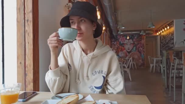 Ένα κορίτσι τρώει πρωινό σε ένα καφέ. — Αρχείο Βίντεο