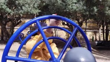 Çocuk parkında fiziksel egzersiz yapan genç bir kadın..