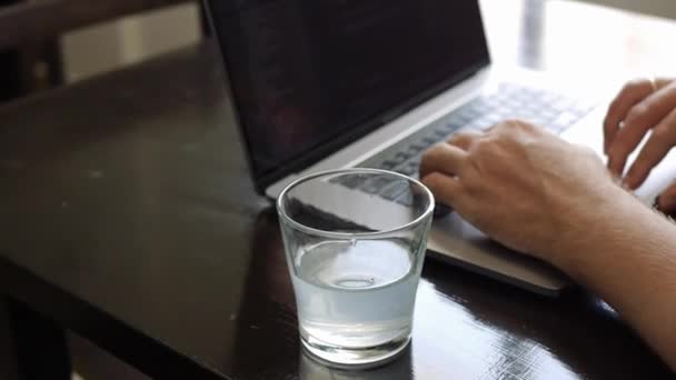 Un hombre trabaja en una laptop en un café — Vídeo de stock