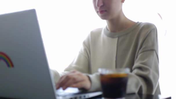 Ein Mädchen arbeitet an einem Laptop in einem Café — Stockvideo