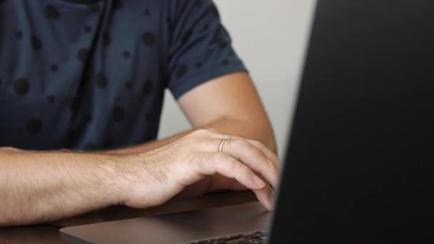Un hombre trabaja en una laptop en un café — Vídeo de stock