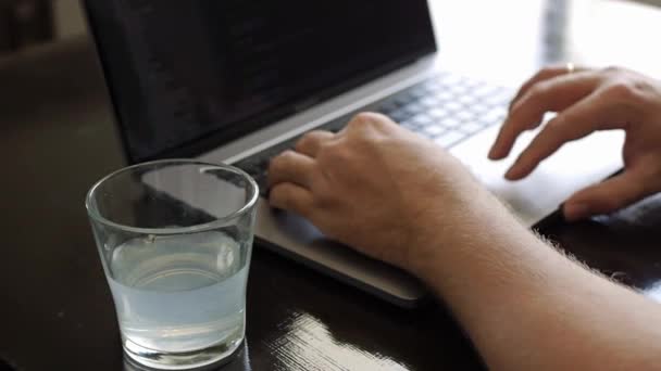Чоловік працює на ноутбуці в кафе — стокове відео