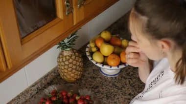 Mutfakta böğürtlen yiyen bir kadın..