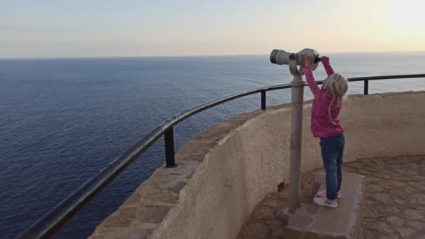Menina olhando através de um telescópio — Vídeo de Stock