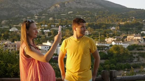Young Couple Outdoors Town Mountain Background Beautiful Pregnant Woman Taking — Video Stock