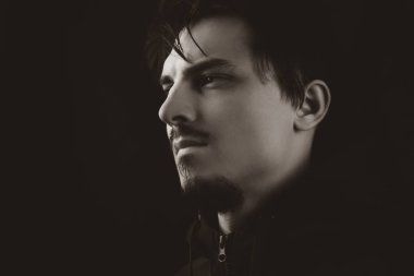 Erkek portresi. Karanlıktaki genç adam. monokrom rengi