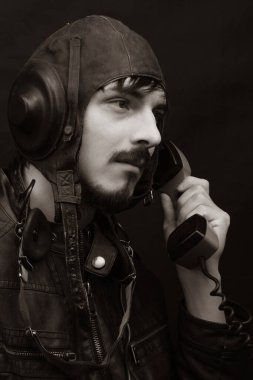 Eski tarz erkek portresi. Siyah arka planda eski model havacılık kıyafeti giyen genç adam.