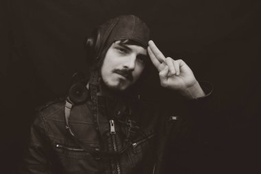 Eski tarz erkek portresi. Siyah arka planda eski model havacılık kıyafeti giyen genç adam.