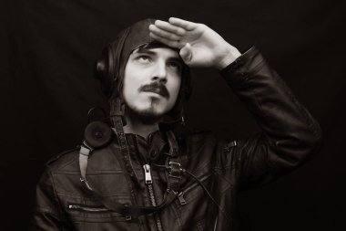Eski tarz erkek portresi. Siyah arka planda eski model havacılık kıyafeti giyen genç adam.