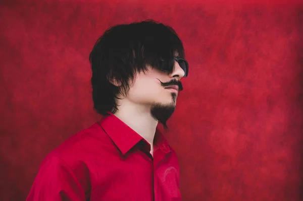 Молодой Человек Темных Очках Красной Рубашке Красном Фоне Мужской Портрет — стоковое фото