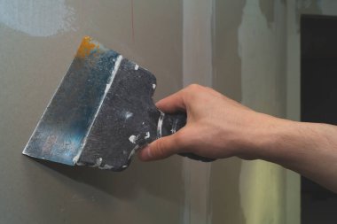 İnşaat spatulasını macunla tutan el. Alçılı mala. yenileme süreci