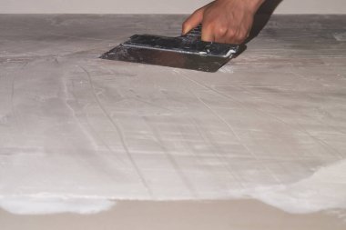 İnşaat spatulasını macunla tutan el. Alçılı mala. yenileme süreci