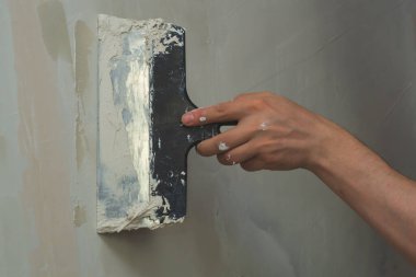İnşaat spatulasını macunla tutan el. Alçılı mala. yenileme süreci
