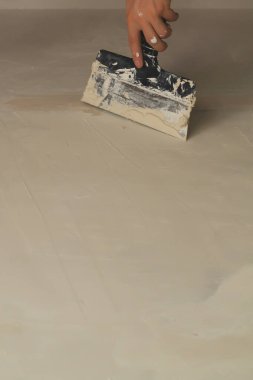 İnşaat spatulasını macunla tutan el. Alçılı mala. yenileme süreci