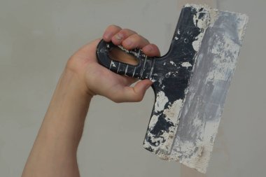 İnşaat spatulasını macunla tutan el. Alçılı mala. yenileme süreci