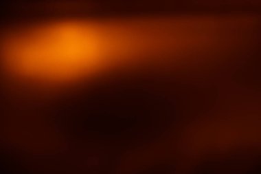 Soyut kahverengi arka plan. Altın ışık karanlıkta parlar.