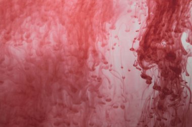 Suyun arka planında kırmızı mürekkep var. Sıvının içine boya sıçramış.