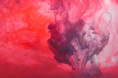 Suda boya var. Sıvı mürekkep. Soyut arkaplan. Sıvı içinde renkli sıçramalar. kırmızı ve mavi renkler