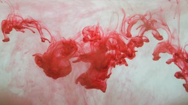 Suyun arka planında kırmızı mürekkep var. Sıvının içine boya sıçramış.