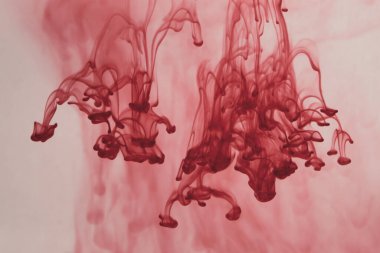 Suyun arka planında kırmızı mürekkep var. Sıvının içine boya sıçramış.