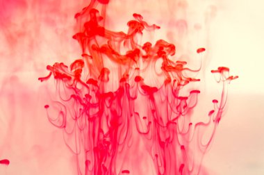 Suyun arka planında kırmızı mürekkep var. Sıvının içine boya sıçramış.