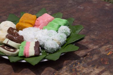 Snacks made from cassava called 'getuk' with various colors and variants. Served on a leaf with a wooden background. Photo of traditional Indonesian food.