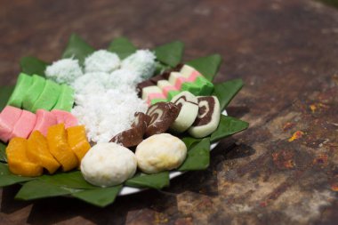 'getuk' adı verilen çeşitli renkler ve çeşitlerle yapılan çerezler. Ahşap arka planı olan bir yaprağın üzerinde servis edilmiş. Geleneksel Endonezya yemeği fotoğrafı.