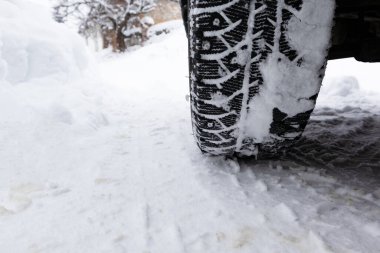 Yakın çekim kış lastiği. Yoldaki araba lastikleri karla kaplı..