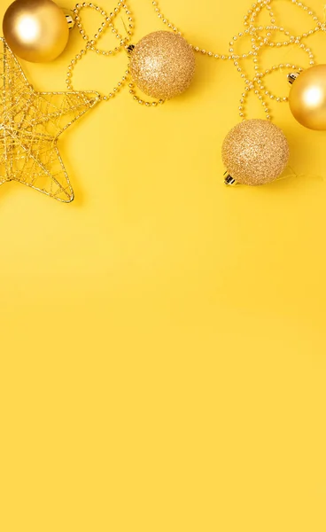 Sarı arka planda Noel altın rengi süslemeler. — Stok fotoğraf