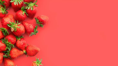 Pembe arka planda olgun çilekler, yaz meyveleri, üst manzara.