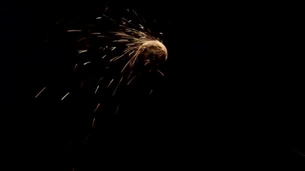 Man works circular saw over the steel. Sparks fly from hot metal on black background. — Stock Video