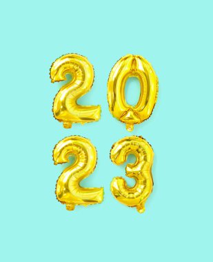 Golden foil balloons with the number 2023. Happy new year and christmas holiday concept. Top view copy space