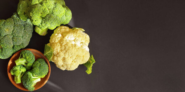 Брокколи и цветная капуста на тёмном фоне, вид сверху