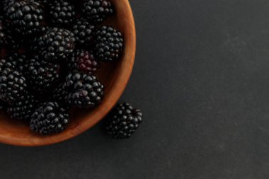 Kahverengi ahşap kasede taze taze böğürtlen