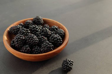 Kahverengi ahşap kasede taze taze böğürtlen