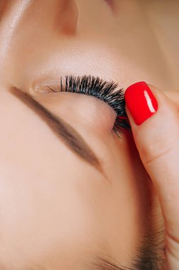 Kirpik uzatma prosedürü. Uzun kirpikli kadın gözü. Yaklaş, seçici odaklanma.