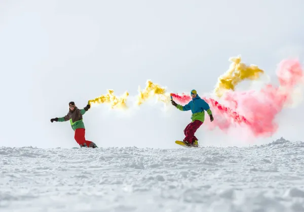 Twee snowboarders met rookfakkel op de skipiste — Stockfoto