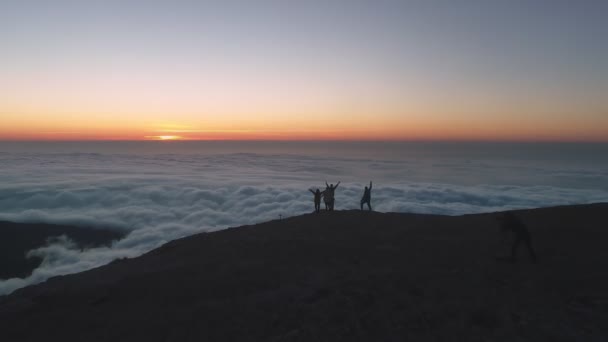 Silhouetten van vrienden bij zonsopgang op bergtop — Stockvideo