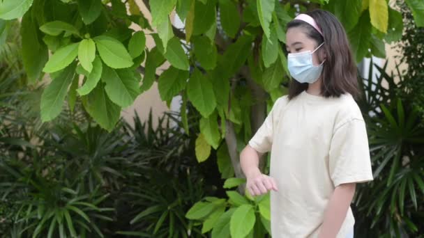 Ein Mädchen Mit Maske Zeigt Freunden Grüße Indem Mit Den — Stockvideo