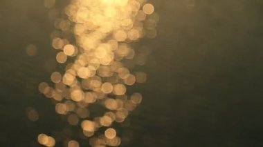 Günbatımı denizinin soyut hareketi, ışıldayan su arka planda çözülmüş, bokeh etkisi