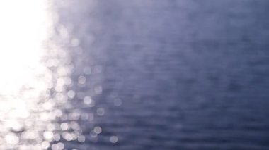 Güneşin doğuşu denizinin soyut hareketi, titreyen su arka planda çözülmüş, bokeh etkisi