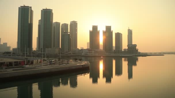 Východ slunce na ostrově Al Reem v Abu Dhabi, město. Siluety vysokých moderních budov, za nimiž vychází slunce. — Stock video