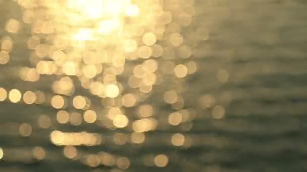 Αφηρημένη κίνηση του ηλιοβασιλέματος της θάλασσας, shimmering νερό defocused φόντο, bokeh αποτέλεσμα — Αρχείο Βίντεο