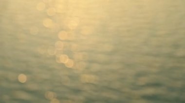 Günbatımı denizinin soyut hareketi, ışıldayan su arka planda çözülmüş, bokeh etkisi