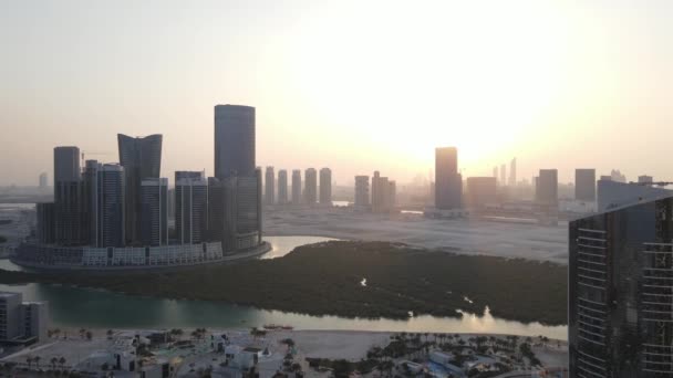Coucher de soleil à Abu Dhabi, vue aérienne sur l'île Al Reem entourée de gratte-ciel modernes entre les mangroves de la mer — Video
