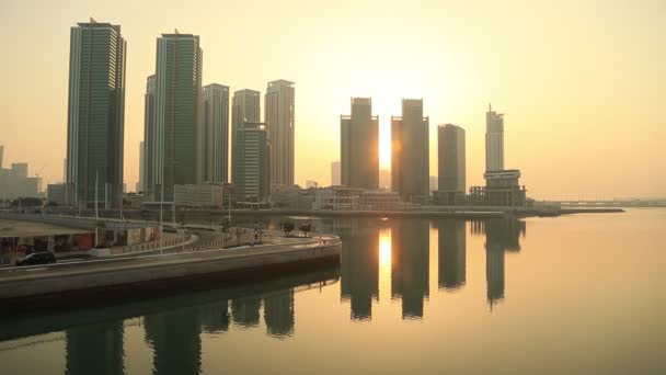 Východ slunce na ostrově Al Reem v Abu Dhabi, město. Siluety vysokých moderních budov, za nimiž vychází slunce. — Stock video